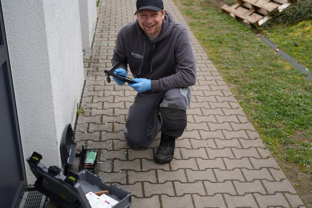 Ein Servicemitarbeiter der PSD Schädlingsbekämpfung dokumentiert Monitoring-Daten auf einem Tablet vor Ort